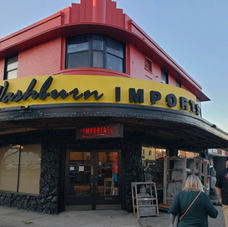 Washburn Imports storefront in Orlando, featuring a curved red façade and vintage-style signage.