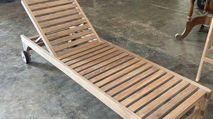 Unfinished custom teak pool lounger with slatted frame and adjustable backrest in an Indonesian furniture workshop.