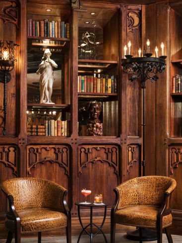 Custom teak wood library cabinetry and carved shelving in an intimate lounge or reading room setting.