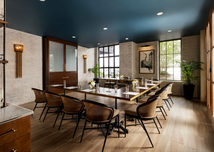 Private dining room with a long wood table, custom cabinetry, and modern lighting.