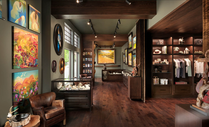 Hotel gallery corridor featuring custom wood floors, cabinetry, shelving, and wall displays.