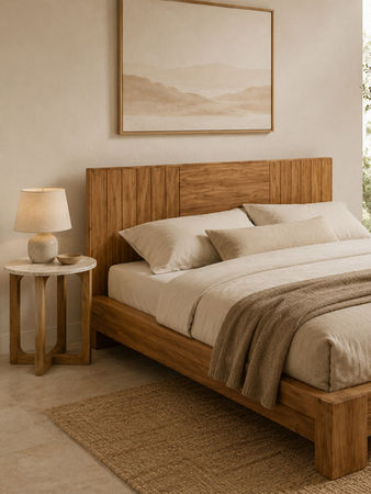Natural teak bed frame with tall headboard, neutral bedding, side table, and warm bedroom decor.
