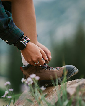 Frau zieht Wanderstuhe an.
