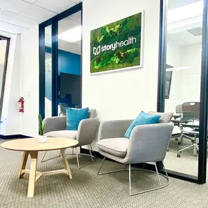 Modern office lobby with chairs and a table.