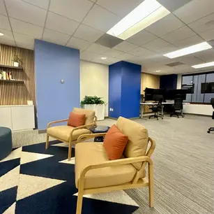 Modern office lounge with chairs and geometric rug.