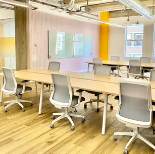 Modern office space with desks and ergonomic chairs.