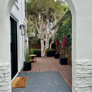 Arched entrance to a garden with wooden deck.
