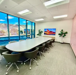 Modern conference room with large table and mountain view.
