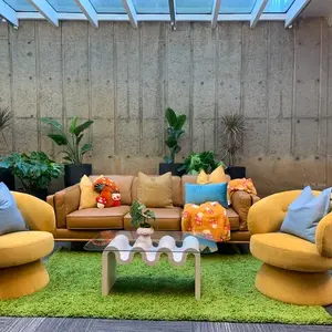 Colorful, modern lounge with yellow furniture and plants.
