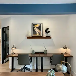 Modern office space with two desks and artwork.