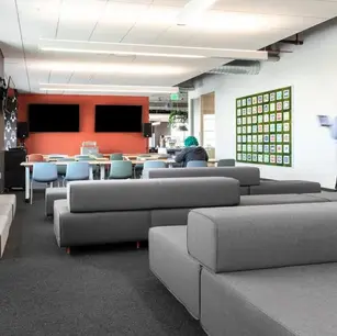 Modern office lounge with gray sofas and wall art.