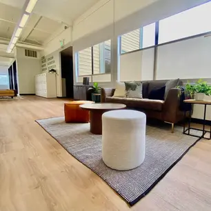 Modern office lounge with plants and comfortable seating.