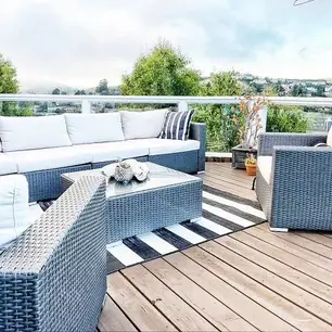 Outdoor patio with wicker furniture and scenic view.