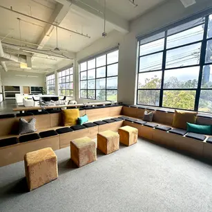 Modern lounge area with large windows and seating.