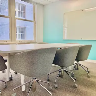 Modern conference room with gray chairs and whiteboard.