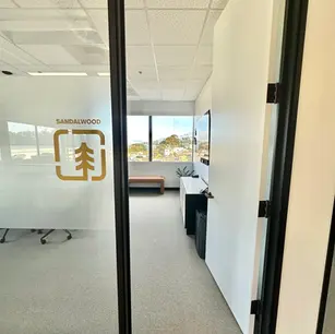 Office entrance with "Sandalwood" logo on glass door.