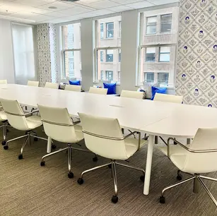 Modern conference room with white chairs and table.