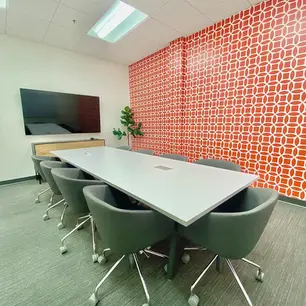 Modern conference room with geometric orange wall design.