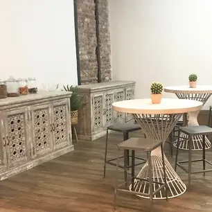 Modern cafe with rustic decor and wooden flooring.