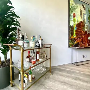 Bar cart with various bottles and glasses.