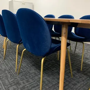 Blue chairs around a wooden conference table.