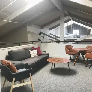 Loft-style office with modern furniture and skylight.