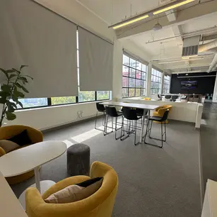 Modern office space with seating and large windows.