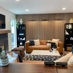 Modern living room with wood paneling and stylish furniture.