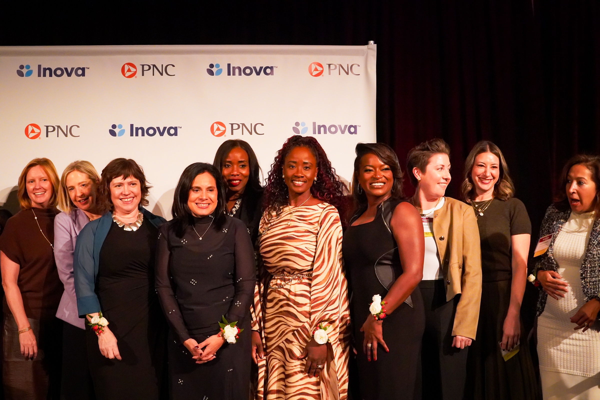 Isabella Piña and guests at the 2026 Women Who Mean Business event backdrop in Washington, DC.
