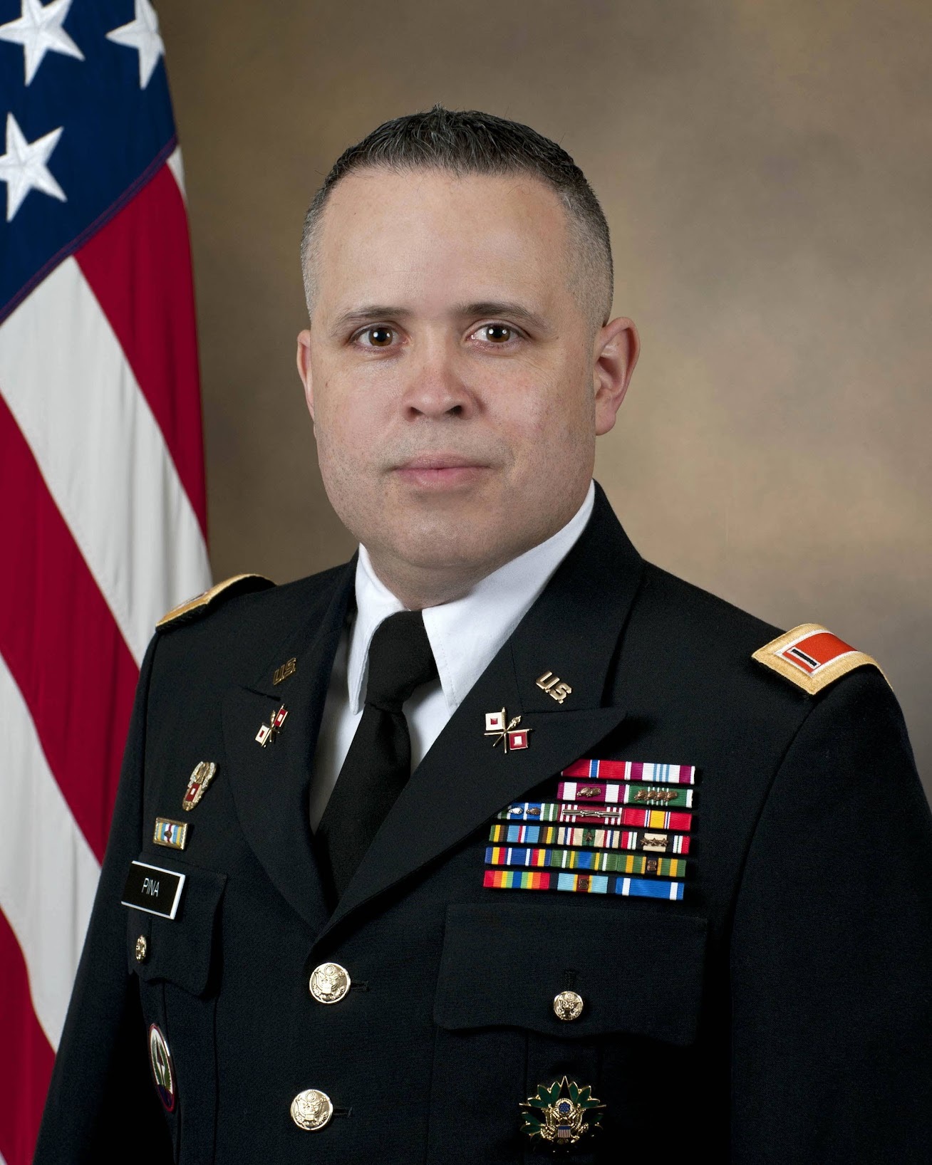 Chief Warrant Officer 5 Rick Pina in United States Army dress uniform, in front of the American flag