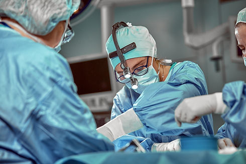Portrait of team of multiethnic surgeons at work in a operation theatre. Several doctors s