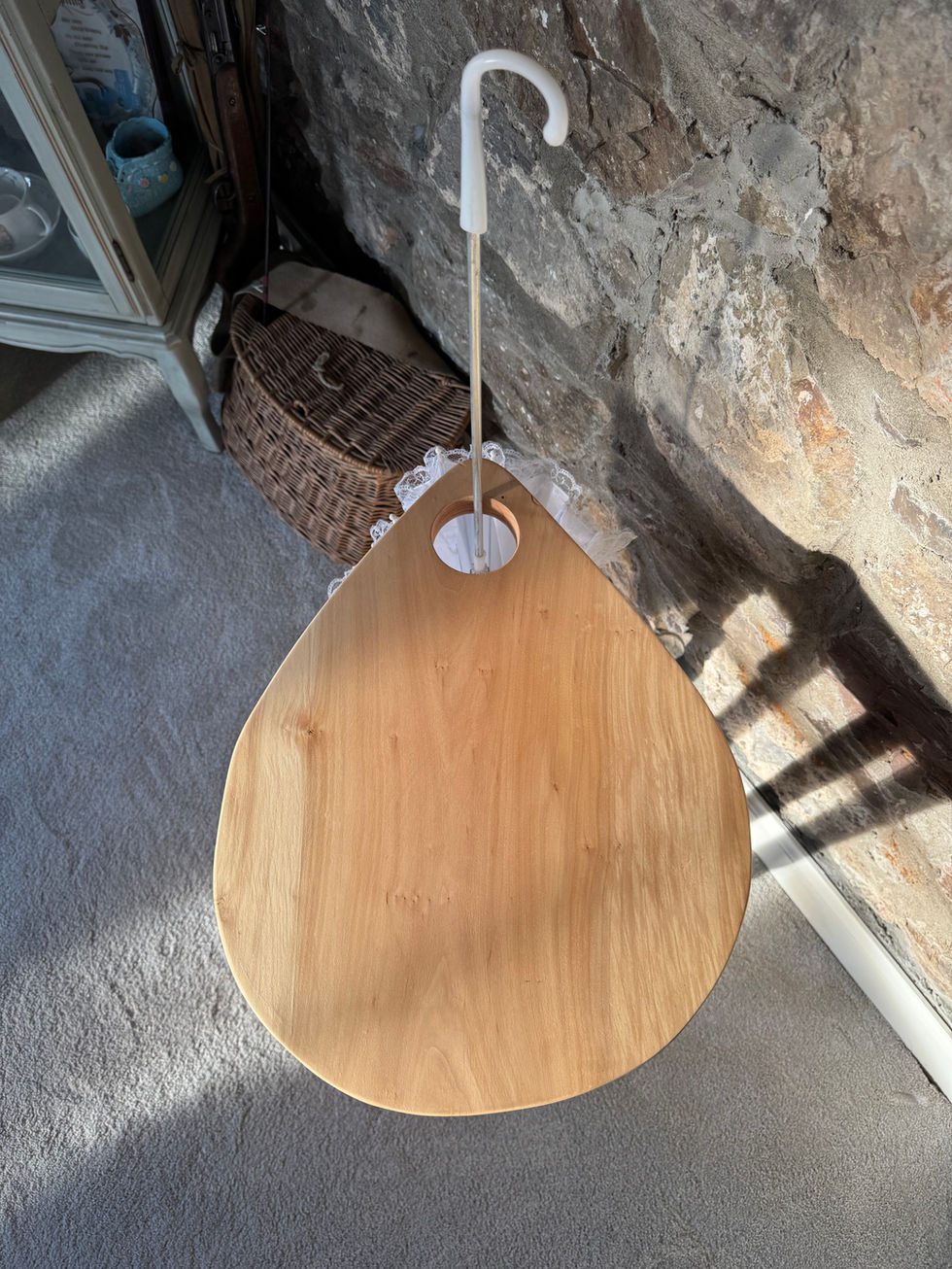 The seat of a wooden stool that is shaped like a rain drop