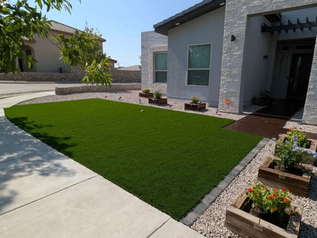 Artificial turf installation completed by A.V.S.A. Designs in El Paso, TX featuring decorative rock, clean edging, and a professionally finished backyard landscape.