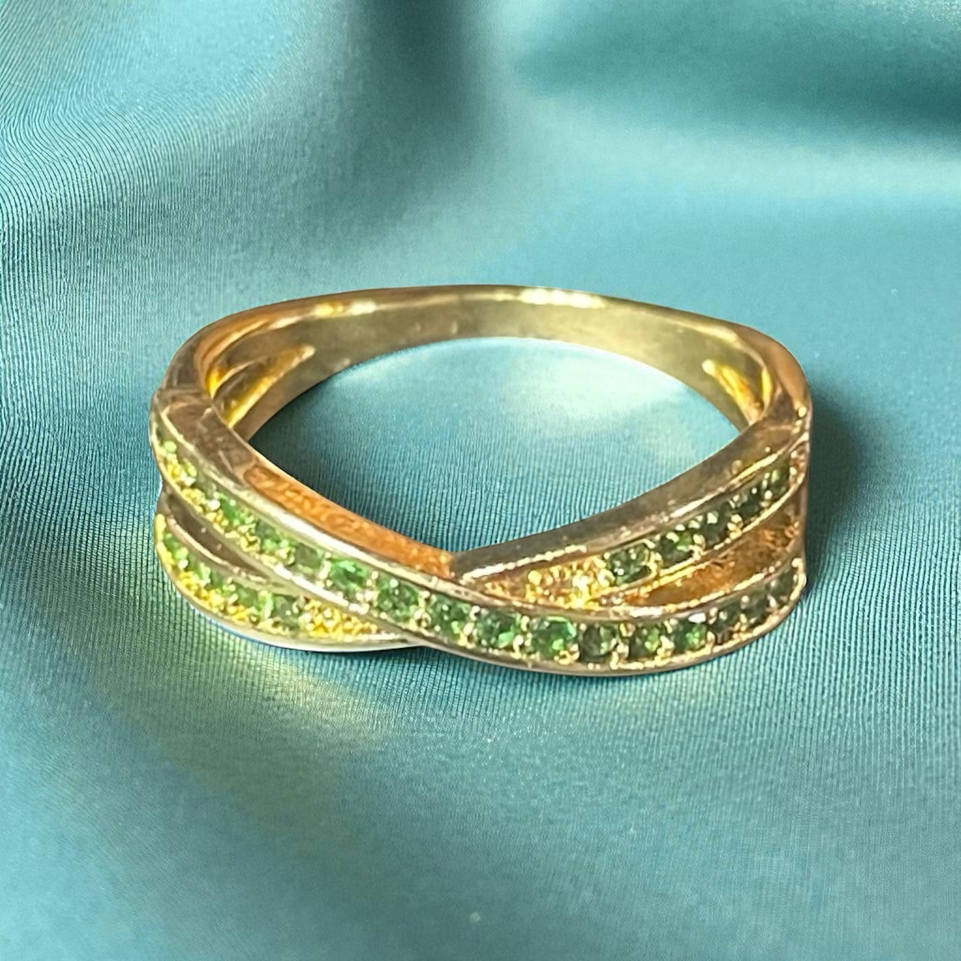 Overlapping Golden Bands with Green Gem Accents