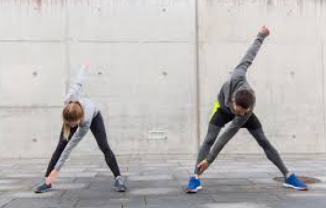 Couple en plein échauffement sportif avant d'aller faire du sport en milieu urbain