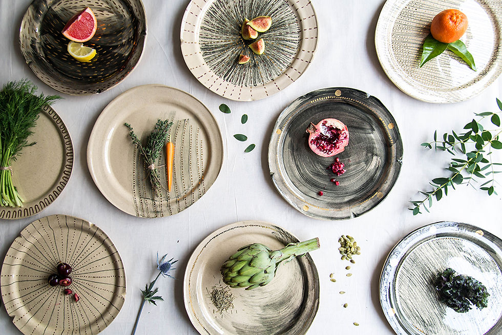 Overhead photo of a group of handmade ceramic plates styled with fresh produce
