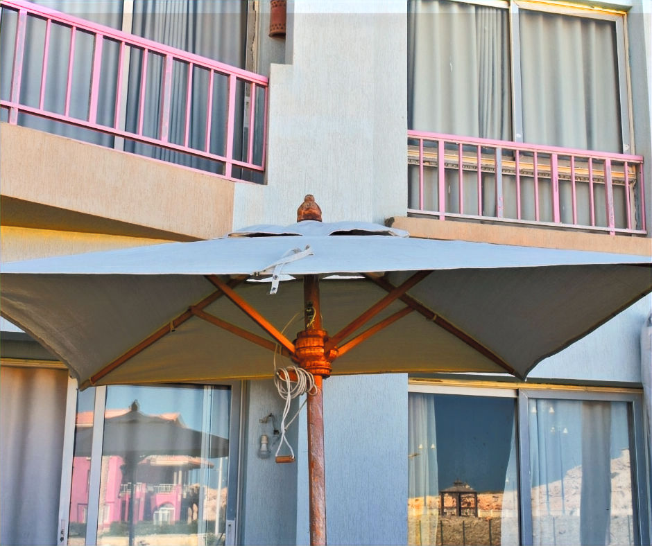 Thumbnail: Large gray patio umbrella with a sturdy wooden pole and frame, designed to provide durable shade for garden or terrace use.