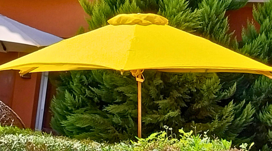 Thumbnail: Yellow SS-Octa Prestige octagon umbrella in a garden