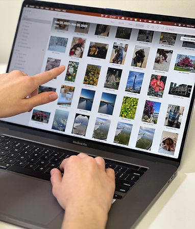 An open laptop to a list of photos