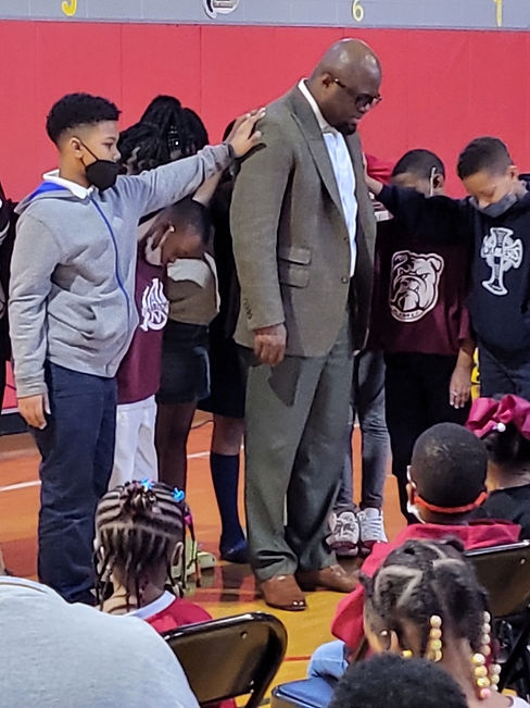 Students praying for the Pastor