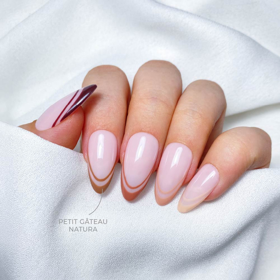 Unhas rosas delicadas com detalhe dourado.