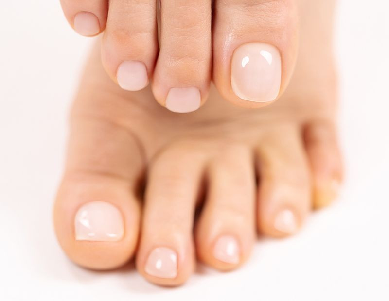Unhas dos pés com esmalte nude claro
