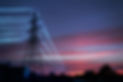 Electric transmission towers with glowing wires against the sunset sky background High vol