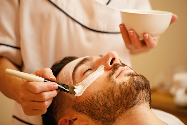 Facial treatment being applied to a man's face for a relaxing massage.