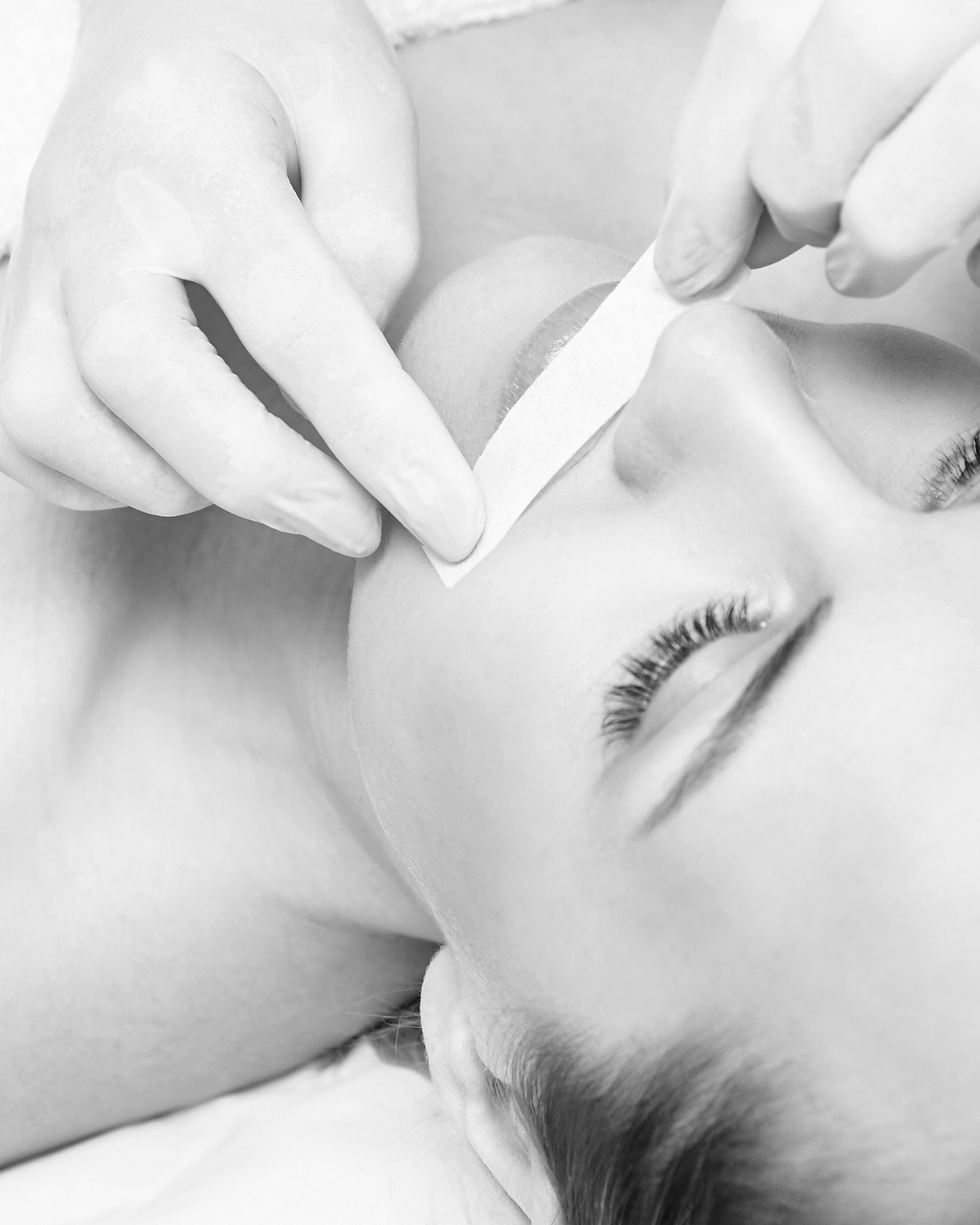 Close-up of facial waxing treatment removing unwanted hair for smooth skin