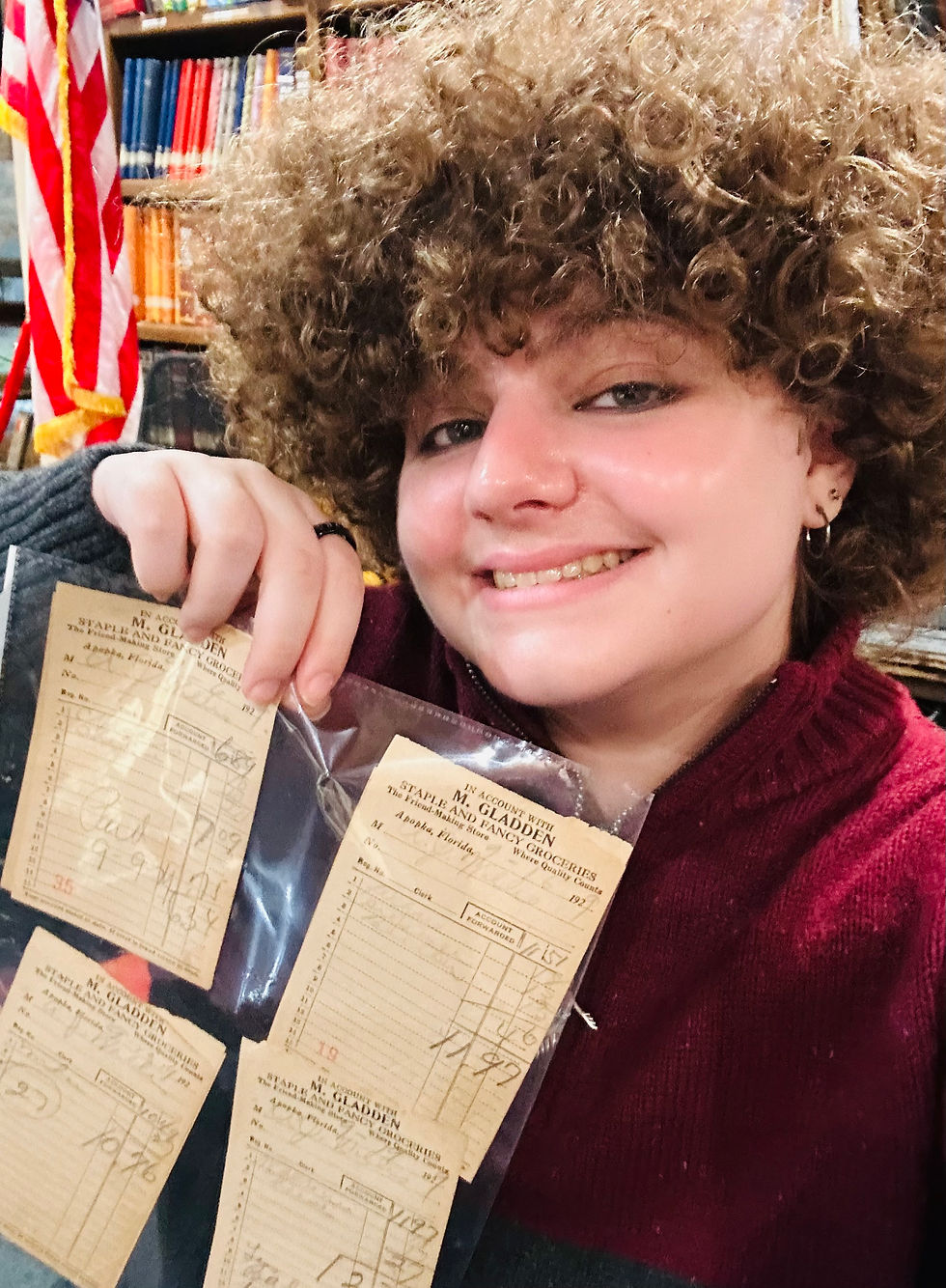 The intern himself in December of 2025, holding a page of Michael Gladden Jr.'s receipts from his grocer, M. Gladden Staple and Fancy Groceries.