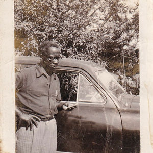 Photograph of Michael Gladden Jr. Standing Beside a Car
