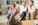a man and woman sit on a couch with their child who is looking away representing distance and pulling away from the parents.