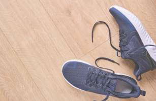 a pair of shoes, dropped on a wooden floor