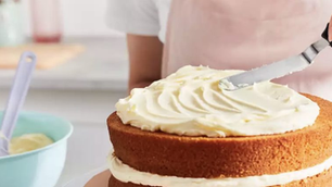 a woman icing a cake